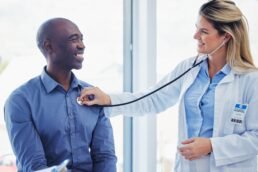 Doctor woman, patient and consultation with stethoscope in hospital for healthcare or health insura